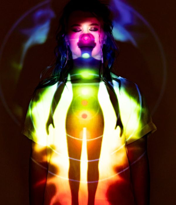 A person in a powerful yoga pose radiating mint colored energy.