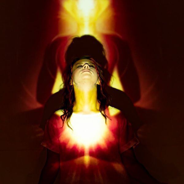 Woman meditating calmly, with a serene mint-colored light effect.